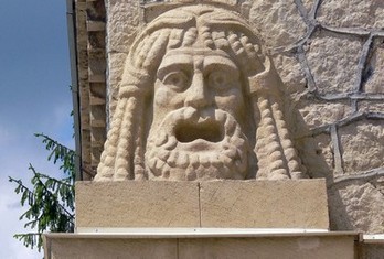 Скульптура лица на углу стены грязелечебницы