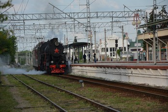 Паровоз пускает пар на железнодорожном вокзале города Ессентуки