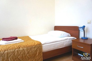 Кровать в спальне в номере одноместный стандарт в корпусе Центральный г.Ессентуки
