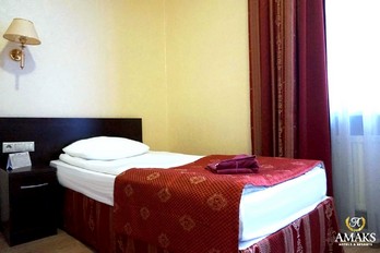 Кровать в спальне номера одноместный Бизнес в корпусе Европейский санатория Шахтёр в городе Ессентуки
