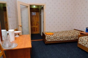 Кровать в спальне в двухместном номере с одной комнатой третьей категории в третьем корпусе санатория Тельмана в Железноводске